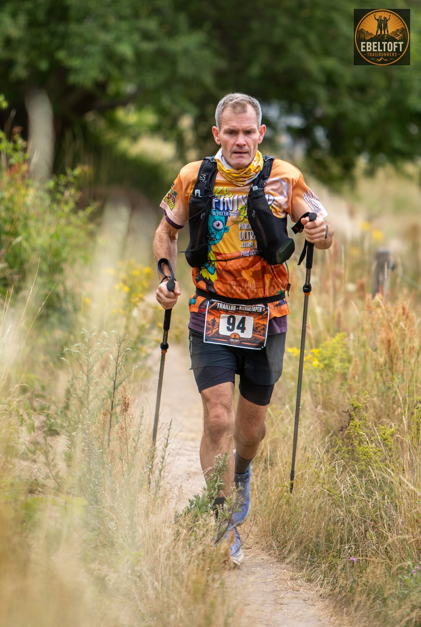 Løber med stave på trailsti gennem det kuperede terræn i Mols Bjerge